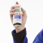 zmywacz w sprayu zmywacz w sprayu tesa - zbliżenie na opakowanie trzymane w dłoni
