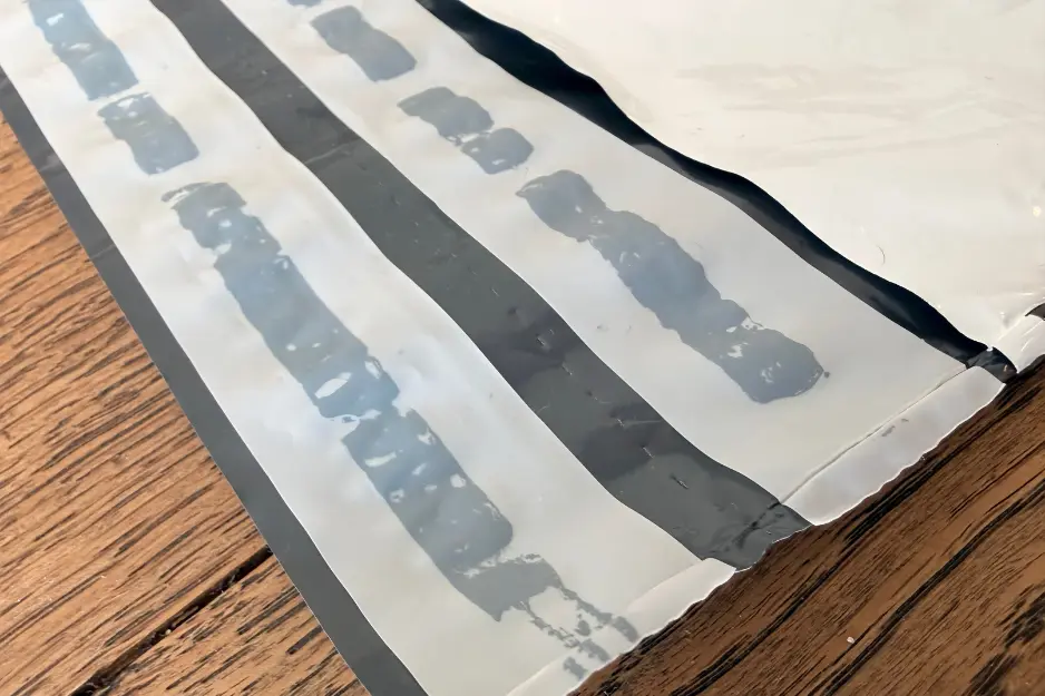 foliopak-kurierski-zamkniecie-podwojne-perforacja Zamknięcie podwójne w foliopaku kurierskim pokazane z bliska, z perforacją dla łatwiejszego otwierania.